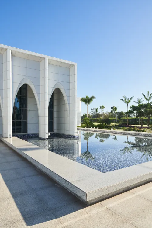 Exterior of the Brasilia Brazil Temple. It features the front of the temple, archways, and reflecting pools. Image was taken during the day.