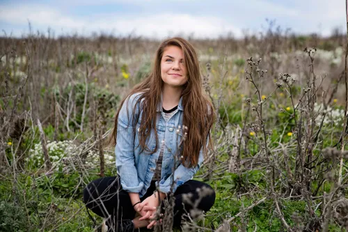 young adult woman sitting in field