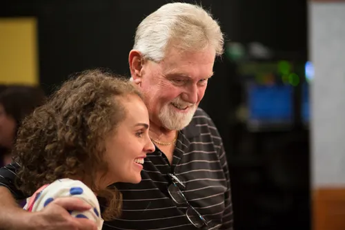 A man with his arm around a woman.  They are smling.