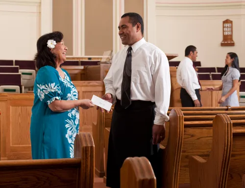 woman giving envelope to bishop