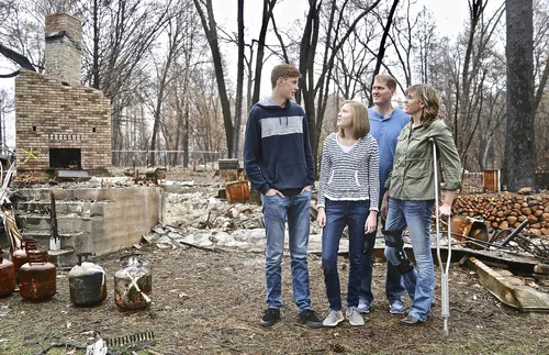 family standing amid ruins of their home