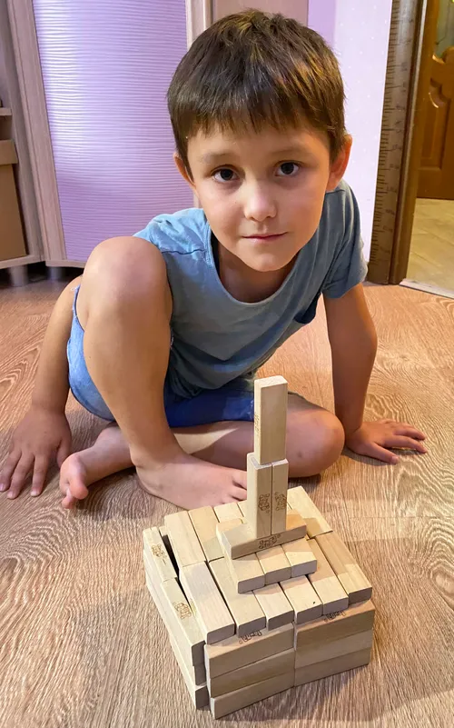 Boy with a temple he made from wooden blocks