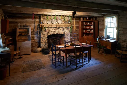 Interior of a nineteenth-century log home showing the hearth and various furniture items.