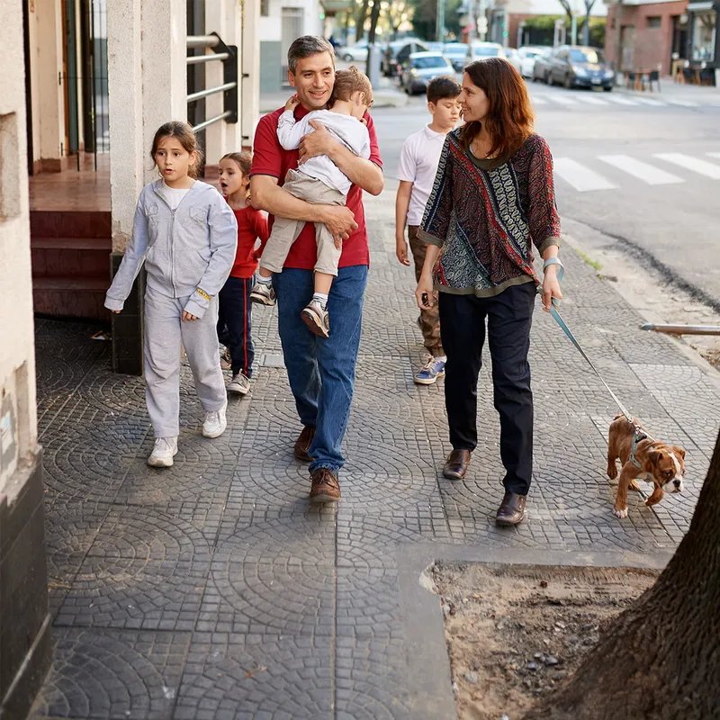 A family walks down the street with their dog