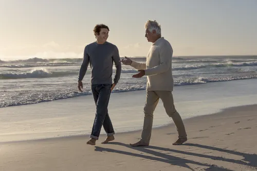 father and son walking on beach