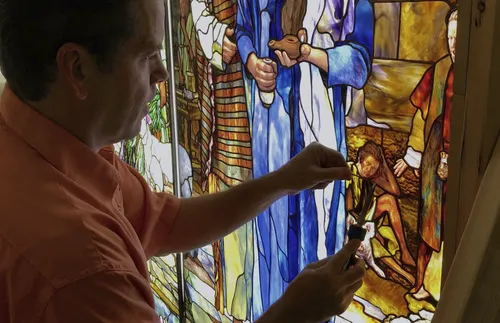 Artist working on stained glass mural