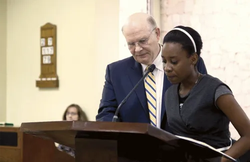 young adult standing next to Elder Renlund