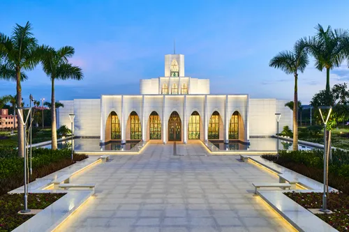 Exterior of the Brasilia Brazil Temple. It features the front of the temple, the entrance area, and trees nearby. 