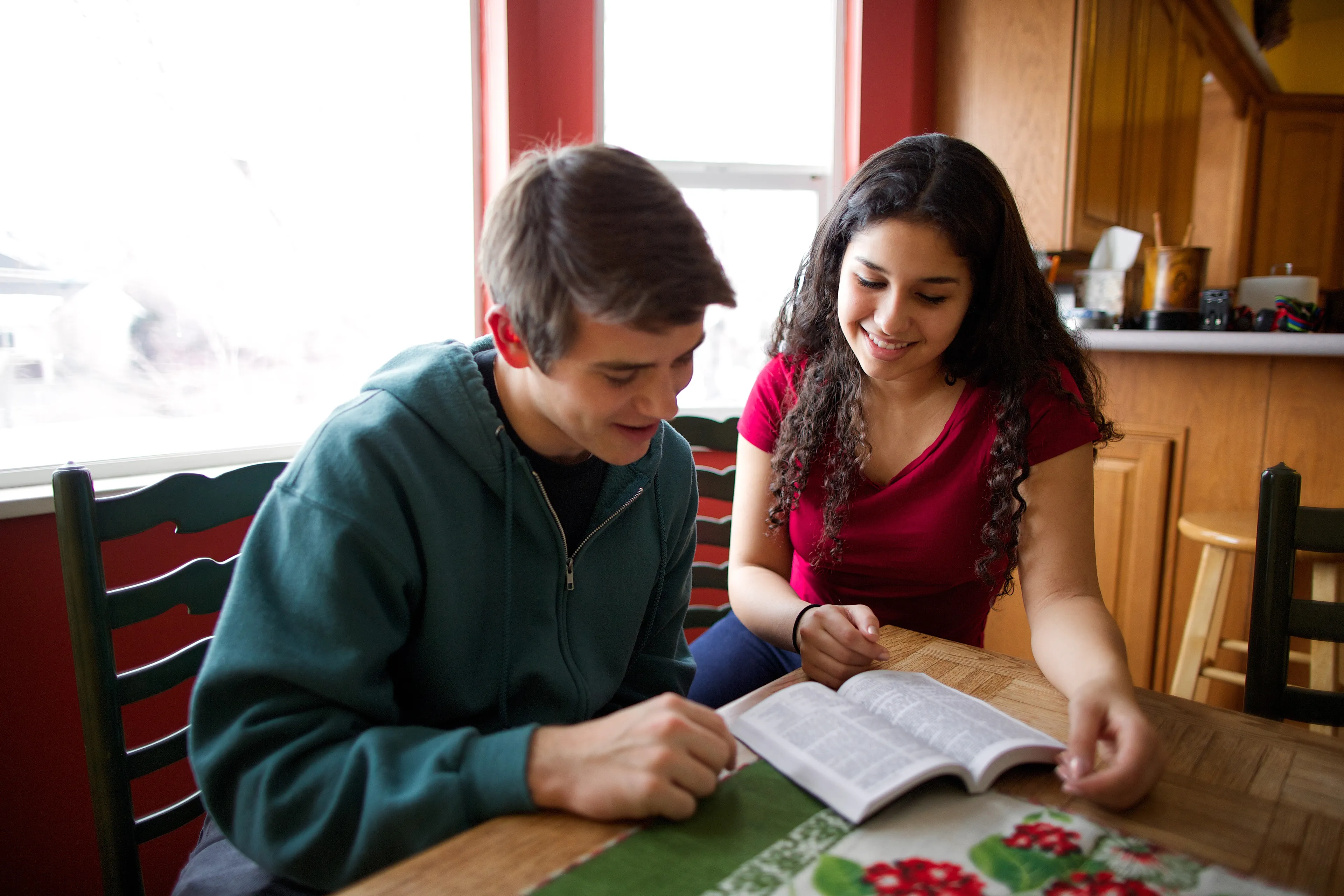 A young man and young woman reading scriptures together.