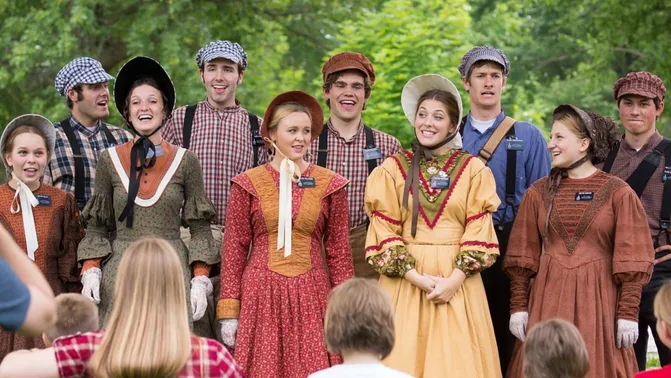 Young female and male missionaries singing songs while in pioneer clothing. 