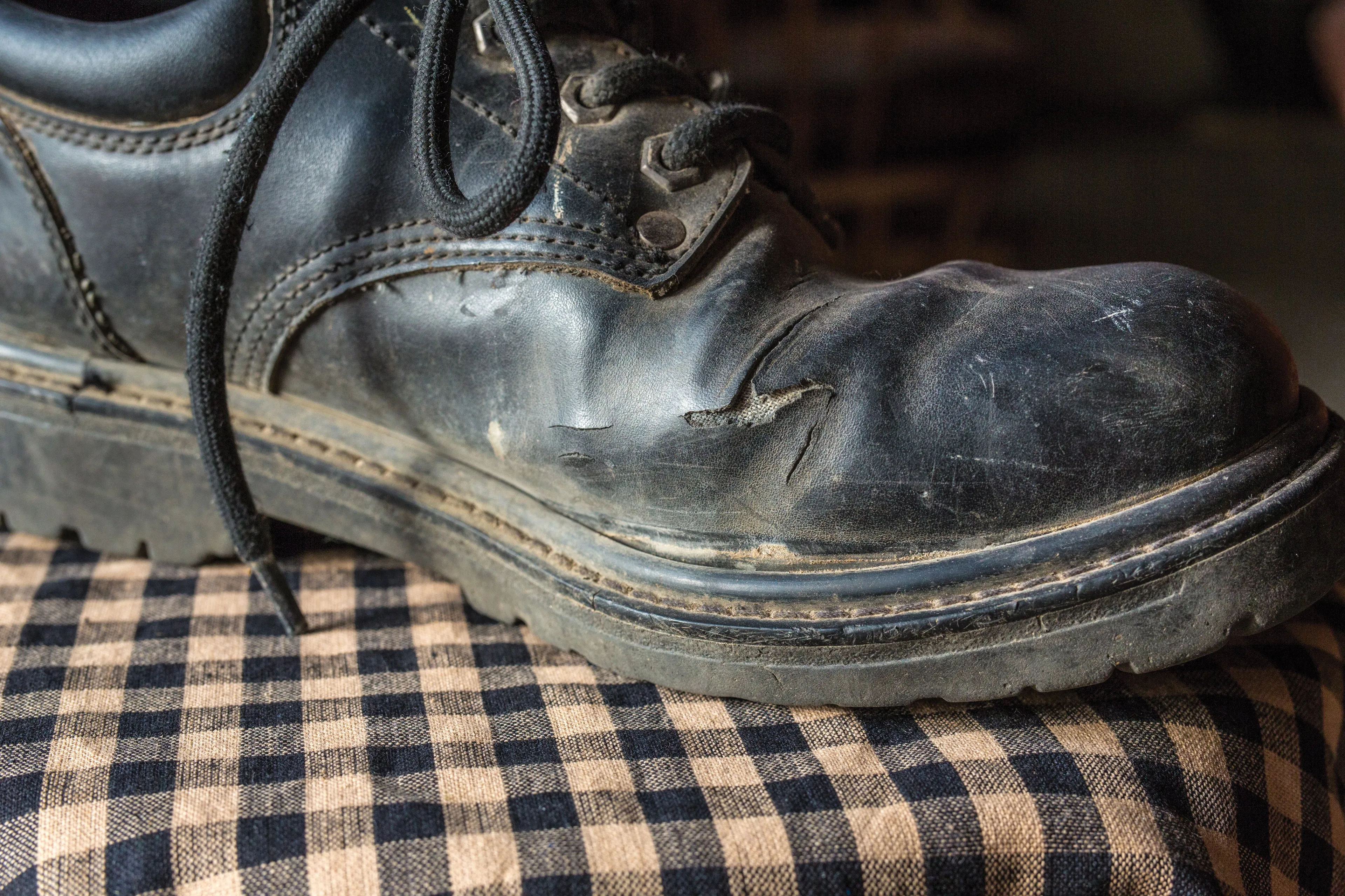 An old black shoe that has begun to wear out.