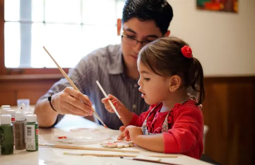 a father and daughter painting together