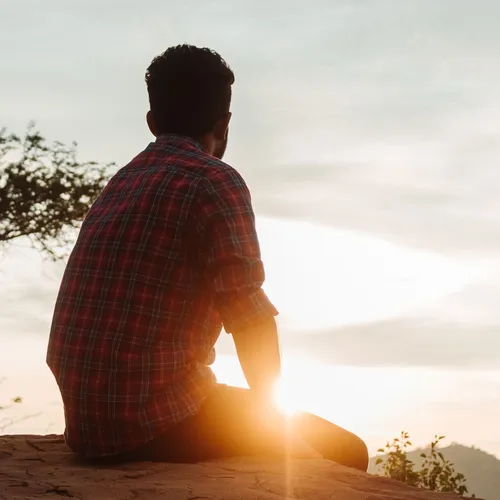 man sitting and watching a sunrise