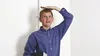 a young man in the corner of a room measuring his height