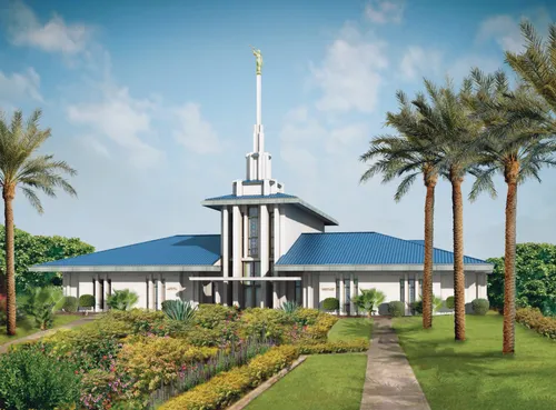 The front of the Papeete Tahiti Temple on a sunny day, with palm trees and other vegetation growing on the temple grounds.