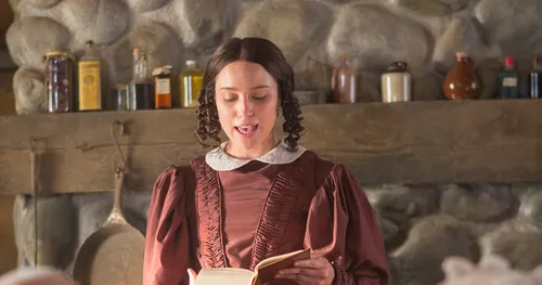 Women reads from scriptures in a re-enactment of the meeting when the Church was organized in the Whitmer home.