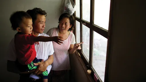 parents and a young boy looking out a window