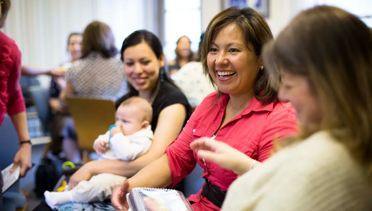 A group of women greet one another during a Relief Society meeting