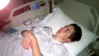 A missionary is lying on a hospital bed. He is sleeping.