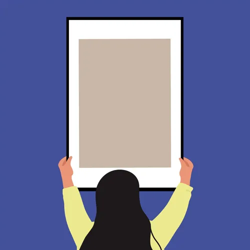 woman hanging an empty frame on a wall