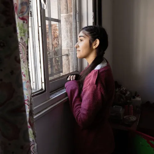 young woman looking out of a window