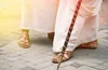 men wearing sandals with a staff