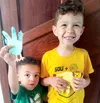 Two young boys holding animal crafts made from the shape of a hand