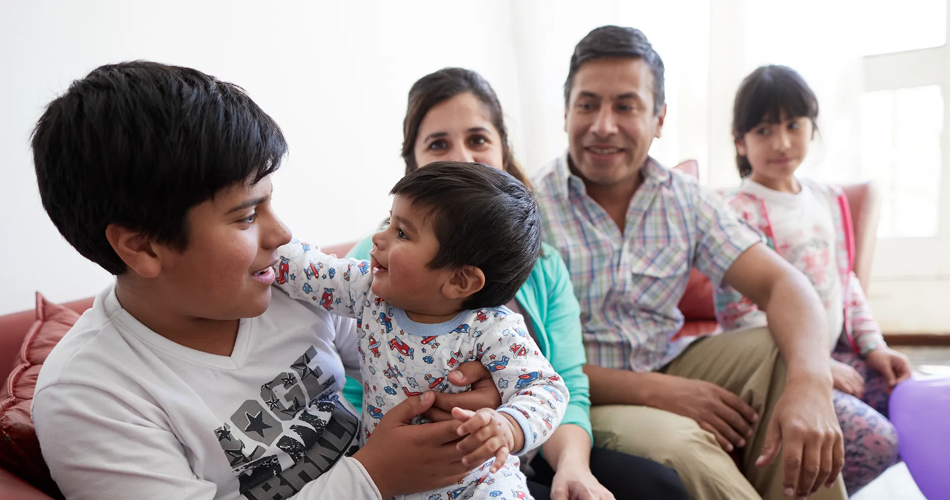 Family sits together on a couch.