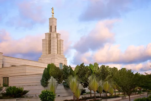 A side view of the Accra Ghana Temple and the trees on the grounds during the early evening hours.