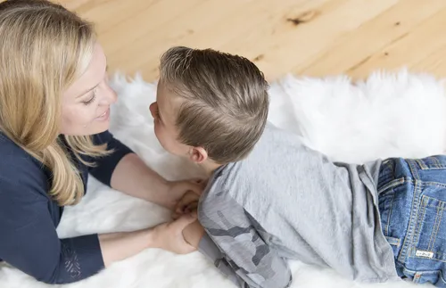 mother and son facing each other holding hands