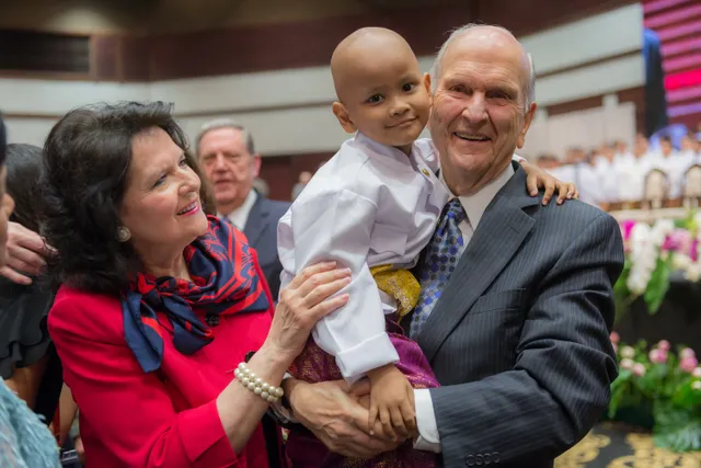 President Russell M. Nelson holds a child with his wife, Wendy, by his side in Bangkok, Thailand, Friday, April 20, 2018.
