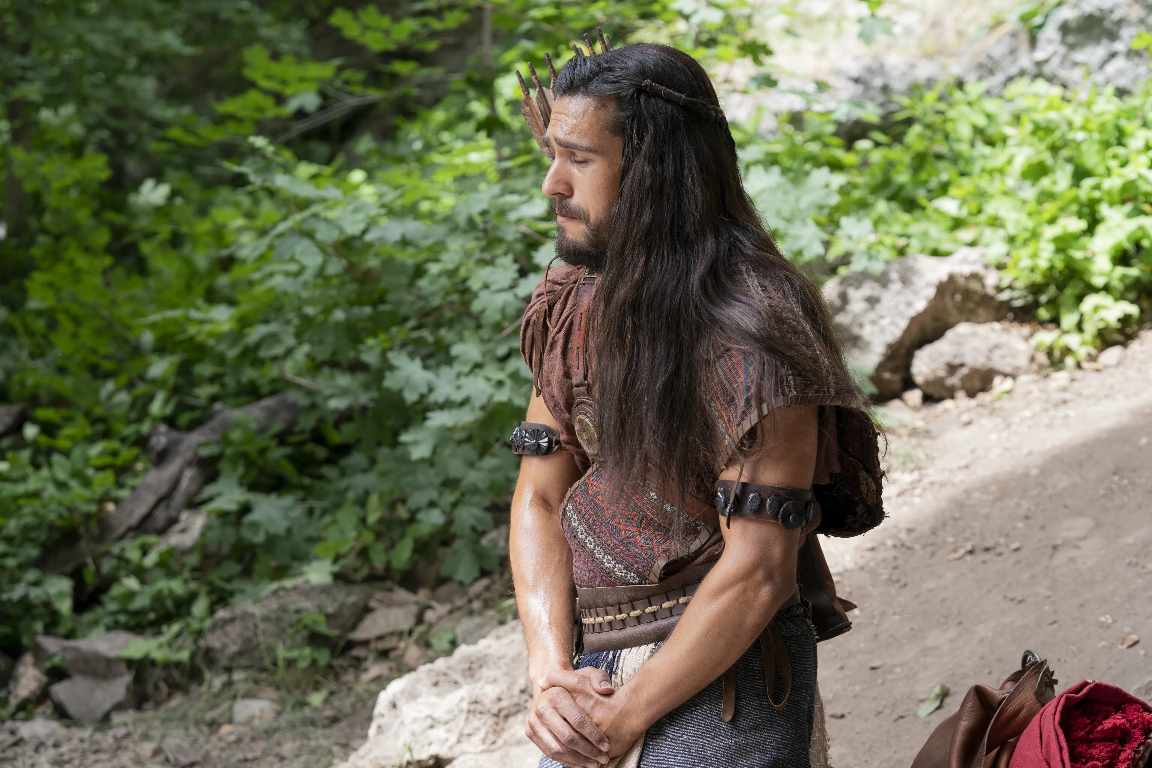 Enos prays in the forest.