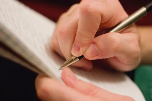 person writing in journal