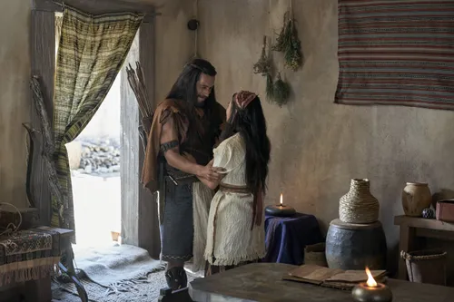 Enos greets his wife in their home.