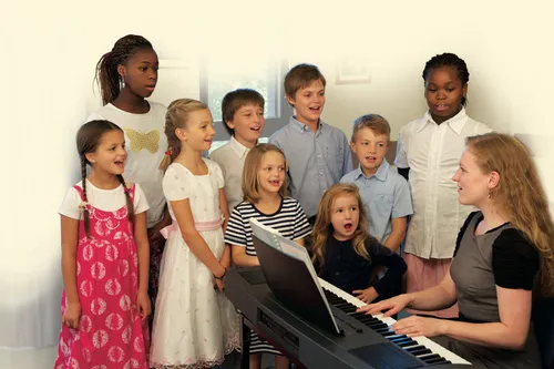 children gathered around a piano singing