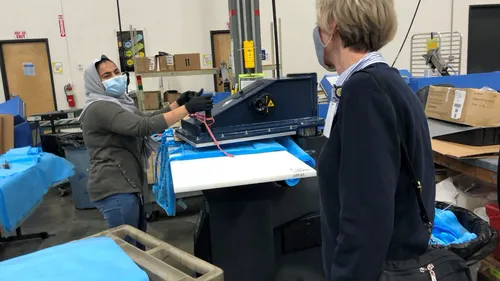 woman cutting fabric bolts