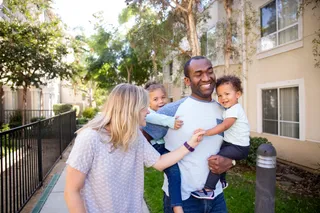 A young family walk down a sidewalk enjoying time together