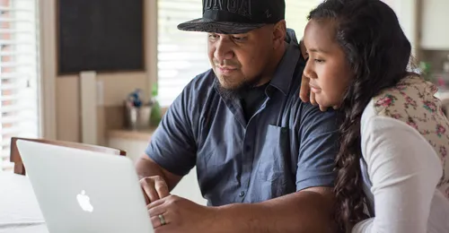 father and daughter looking at a computer screen together