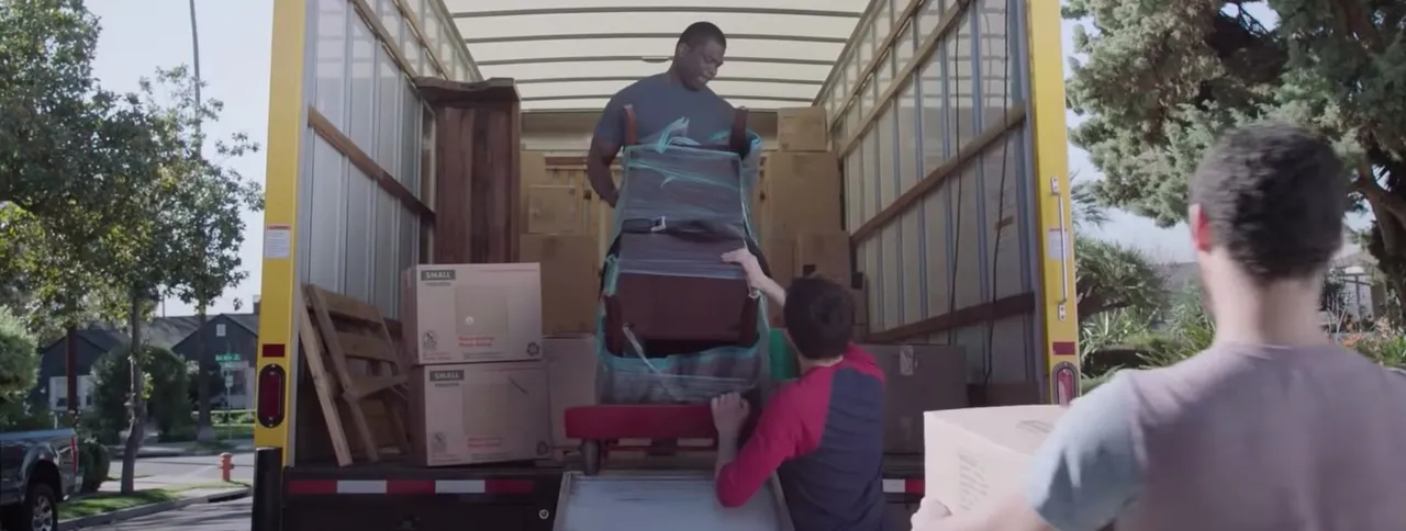 A man helps move furniture from a moving van