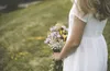 woman in white dress holding flowers