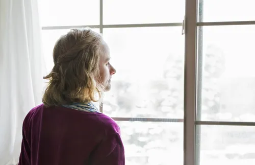 young woman looking out window