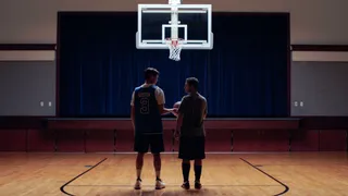 Two men standing on a basketball court together