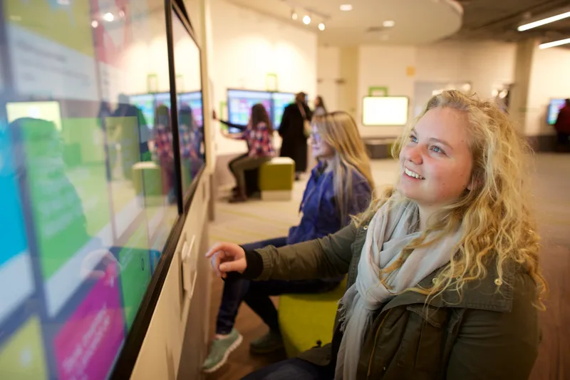 A young woman interacts with a family history machine