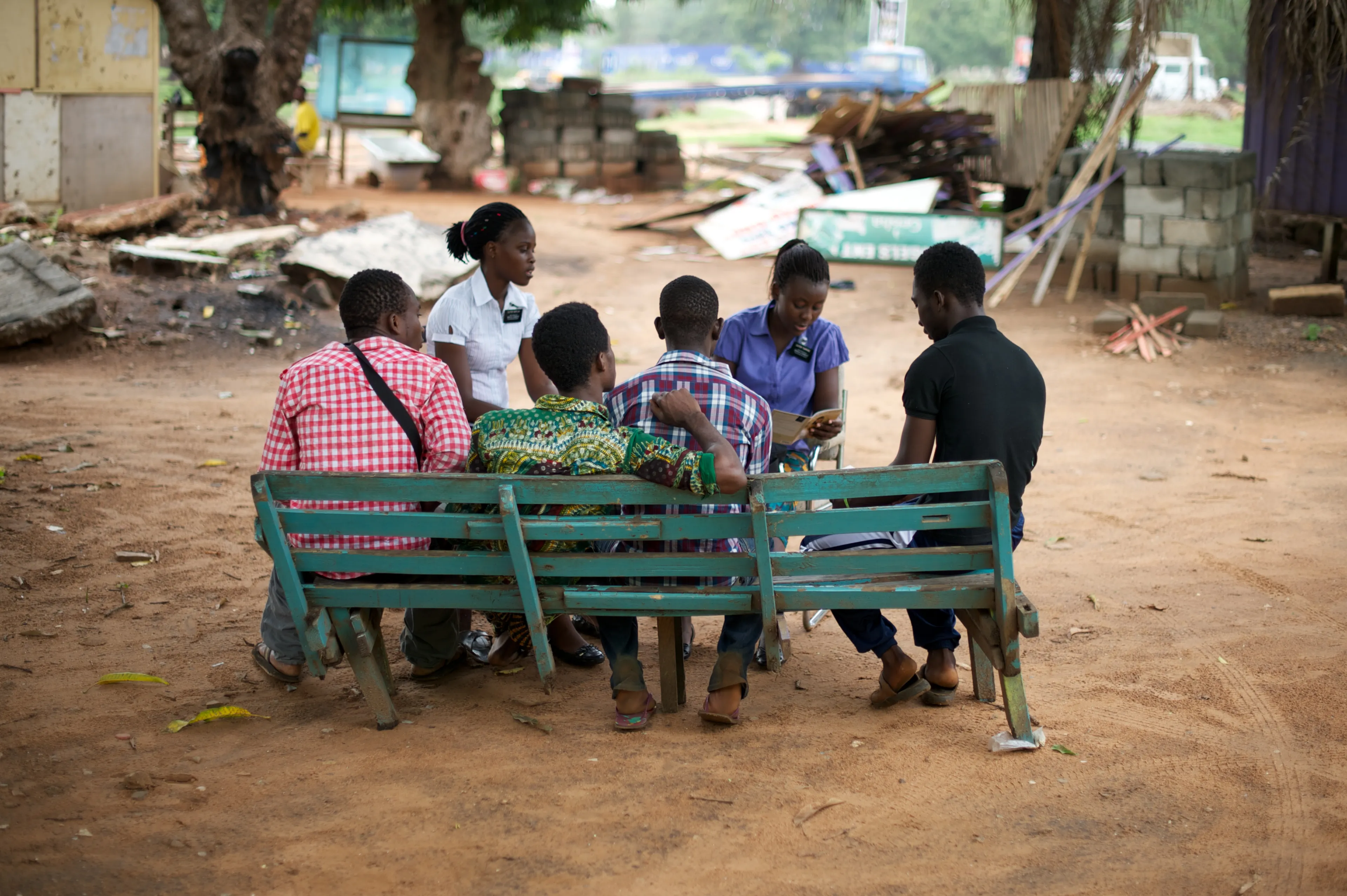 Two sister missionaries teaching a group of four teenage boys.
