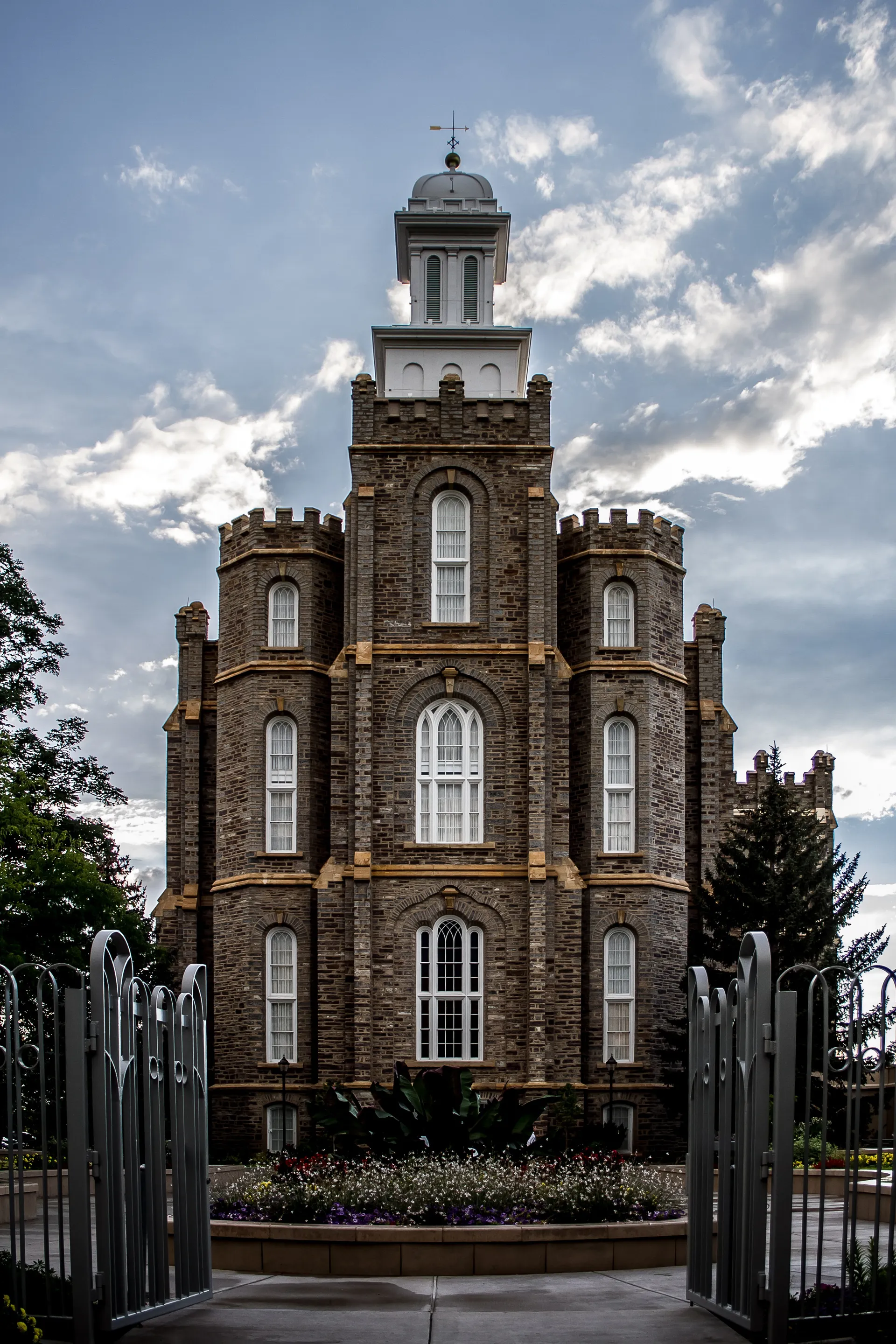 The front view of the Logan Utah Temple, including the scenery and gates.