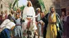 Jesus Christ riding a donkey and people waving palm fronds