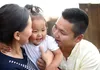 mother and father holding small girl