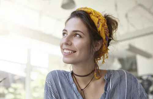 woman with headband smiling in the light