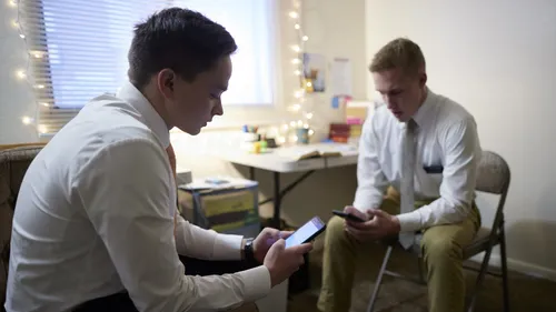 missionaries studying on phones