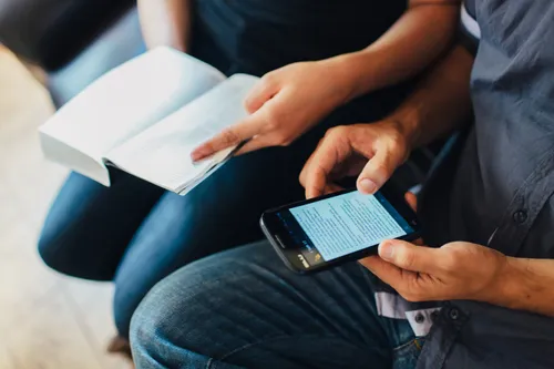 Couple studying using books and phone in Brazil